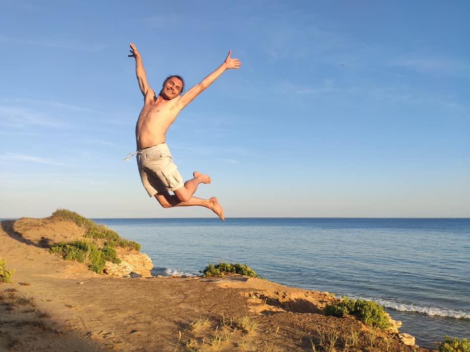 DJ Drissa sautant en pleine liberté au bord de la mer, incarnant l’énergie et la passion de l’Ecstatic Dance | Lez'Art Festival 2025